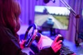 Asian young teenager driver girl playing super speed car game with steering wheel and gear controller simulation gadget closeup