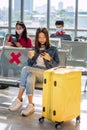 Asian girl using phone at airport departure waiting seat