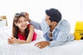 Asian young traveler lover couple in casual outfit with sunglasses and hat laying down smiling together on bed holding passport Royalty Free Stock Photo