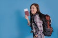 Asian young traveler in summer casual wear with passport and backpack on blue studio background Royalty Free Stock Photo