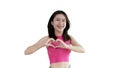 Asian young woman with bright smile making heart symbol shape with hands Royalty Free Stock Photo