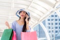 Asian young woman at the city with shopping bags talking on mobile phone. Royalty Free Stock Photo