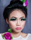 Asian Young Woman Close-up With False Dotted Feather Eyelashes, Graphic Make-up and Pink Flowers in Her Head and Shoulder, Looking