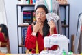 Asian young woman dressmaker designer holding dollars covering mouth with hand, shocked and afraid for mistake Royalty Free Stock Photo