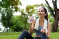Asian young women drink water from a plastic bottle after exercises or sports. Asian woman running in garden. Beautiful fitness Royalty Free Stock Photo