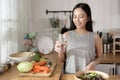 Asian young woman drinking fresh water in kitchen at home , healthy lifestyle concept Royalty Free Stock Photo