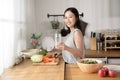 Asian young woman drinking fresh water in kitchen at home , healthy lifestyle concept Royalty Free Stock Photo