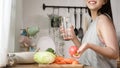 Asian young woman drinking fresh water in kitchen at home , healthy lifestyle concept Royalty Free Stock Photo