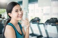 Asian young woman drinking water after exercise in sport club