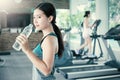 Asian young woman drinking water after exercise in sport club