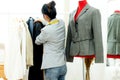 Asian young women fashion designer  working on her designer in the showroom,  Lifestyle Stylish tailor taking measurements on mann Royalty Free Stock Photo