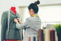 Asian young women fashion designer  working on her designer in the showroom,  Lifestyle Stylish tailor taking measurements on mann Royalty Free Stock Photo