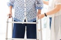 Asian young woman helping senior woman in using walker during rehabilitation, close up of carer supporting her elderly grandmother Royalty Free Stock Photo