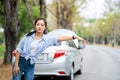 Asian young woman hitchhiking on highway, needing emergency assistance, having road accident
