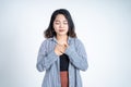 Asian young woman holding chest while feeling relieved Royalty Free Stock Photo