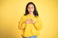 Asian young woman holding chest while feeling relieved Royalty Free Stock Photo