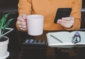 Asian young woman holding coffee cup and using smartphone shopping online-calculate home salary and expenses. concept saving money Royalty Free Stock Photo