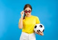 Asian Young Woman holding a soccer ball over isolated blue background, sport concept Royalty Free Stock Photo