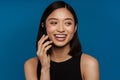 Asian young woman laughing while talking on mobile phone Royalty Free Stock Photo