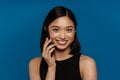 Asian young woman laughing while talking on mobile phone Royalty Free Stock Photo