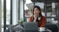 asian young woman listening music with headphone and streaming music from laptop on sofa relaxing at home Royalty Free Stock Photo