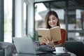 asian young woman listening music with headphone and streaming music from laptop on sofa relaxing at home Royalty Free Stock Photo