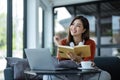 asian young woman listening music with headphone and streaming music from laptop on sofa relaxing at home Royalty Free Stock Photo