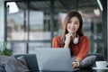 asian young woman listening music with headphone and streaming music from laptop on sofa relaxing at home Royalty Free Stock Photo