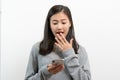 Asian young woman looking on mobile phone and have surprised facial expression Royalty Free Stock Photo