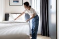 Asian young woman making bed arranging blanket,changing bedding in her room,happy smiling teen girl cleaning,tidying up the Royalty Free Stock Photo