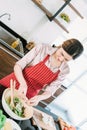 Asian young Woman making salad dressing in modern kitchen Royalty Free Stock Photo