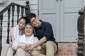 Asian woman and man hug and take care senior parent grandmom with happy smile on outdoor terrce house