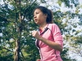 Asian young woman on mark to set ready for jogging exercise to build up her body on glass in warm light morning. Royalty Free Stock Photo