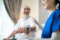 Asian young woman nurse at nursing home taking care of senior elderly man sit on sofa. Caregiver Therapist doctor examining an old Royalty Free Stock Photo