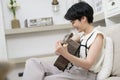 Asian young woman is playing guitar on sofa at home , happy relaxing lifestyle concept Royalty Free Stock Photo