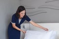 Asian young woman room maid making arrange bed pillow in hotel. Royalty Free Stock Photo