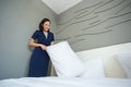 Asian young woman room maid making arrange bed pillow in hotel. Royalty Free Stock Photo