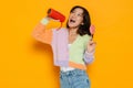 Asian young woman singing while posing with music column and lollipop