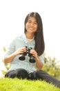 Asian young woman sit on mound seeking binoculars . Royalty Free Stock Photo