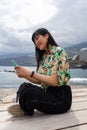 Asian young woman sitting cross-legged chatting with her smartphone. Royalty Free Stock Photo