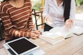 Asian young woman sitting pointing studying examining, Tutor books with friends Young students campus helps friend catching up and