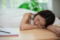 Asian young woman sleep on work table in bedroom