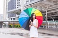 Asian young woman smling and holding umbrella in city,Lifestyle concept,Happy and smiling