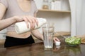 Asian young woman in sportswear drinking milk in kitchen at home , healthy lifestyle concept Royalty Free Stock Photo