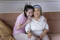 Asian young woman take care and support with hug, that make feel good and smile older mother in living room. family concept