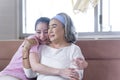 Asian woman take care and  support with hug, that make feel good and smile older mother in living room. family concept Royalty Free Stock Photo