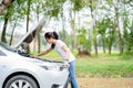 Asian young woman trying to fix this broken car on the street Royalty Free Stock Photo