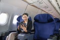 Asian young woman using tablet sitting near windows at first class on airplane during flight, Traveling and Business Royalty Free Stock Photo