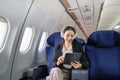 Asian young woman using tablet sitting near windows at first class on airplane during flight, Traveling and Business Royalty Free Stock Photo