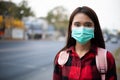 Asian Young woman walking in the city wearing face mask because of air pollution, particulates and for protection flu virus, Royalty Free Stock Photo